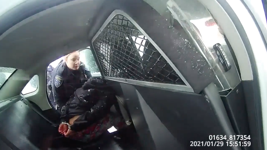 A frame from a Rochester Police Department body-camera video shows a girl in handcuffs in the back of a police cruiser.