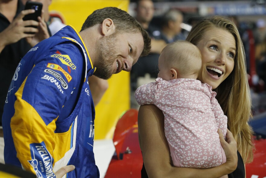 Dale Earnhardt Jr., left, looks at his daughter, Isla, and his wife Amy on pit row prior to an Xfinity Series NASCAR auto race at Richmond Raceway in Richmond, Va., Friday, Sept. 21, 2018.