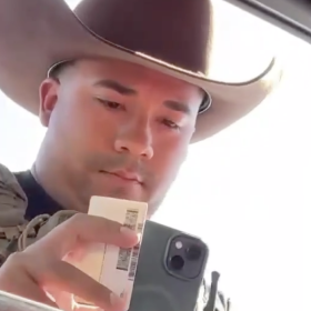 An unidentified Immigration and Customs Enforcement officer examines the driver's license of Dodge City, Kansas, resident Guadalupe Navarrete on Sept. 23, 2026. Navarrete was driving with her father Frank Duran. They were not detained.