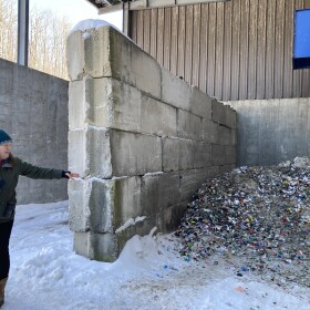 Lindsey Walker, head of recycling outreach and market development for Emmet County's recycling program, points to a pile of crushed glass that will later be picked up and taken to Ohio. From there, it's cleaned and recycled into fiberglass insulation and other products. (Photo: Ellie Katz/IPR News)