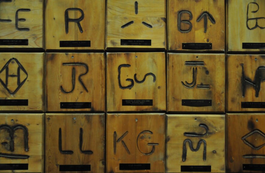 Brands from ranches around Oklahoma hang on the wall at OKC West Livestock Market in El Reno, Okla.