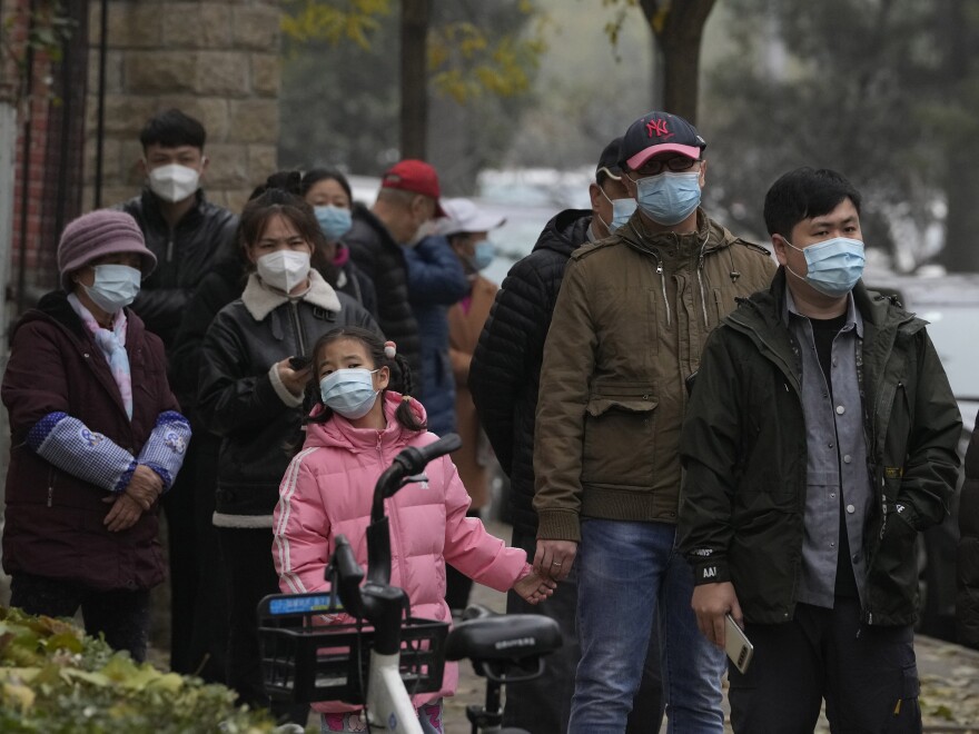 Residents line up for COVID tests in Beijing, Thursday, Nov. 24, 2022. China is expanding lockdowns, including in a central city where factory workers clashed this week with police, as its number of COVID-19 cases hit a daily record.
