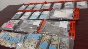 cash and drugs in evidence bags on a table