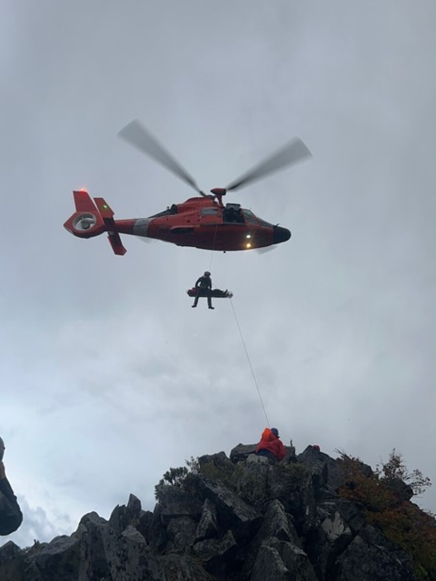 A Coast Guard MH-65 Dolphin helicopter crew hoists an injured hiker off of North Sister on Sept. 5, 2026.