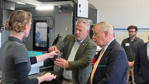 U.S. Rep. Eric Sorensen (D-Moline), center, and U.S. Sen. Dick Durbin (D-Illinois) look at a part produced by ASTRO America Midwest, during a plant open house at their Moline facility, Thursday, Oct. 29. 2026.