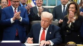 President Donald Trump signs the funding bill to reopen the government, in the Oval Office of the White House, Wednesday, Nov. 12, 2025, in Washington.