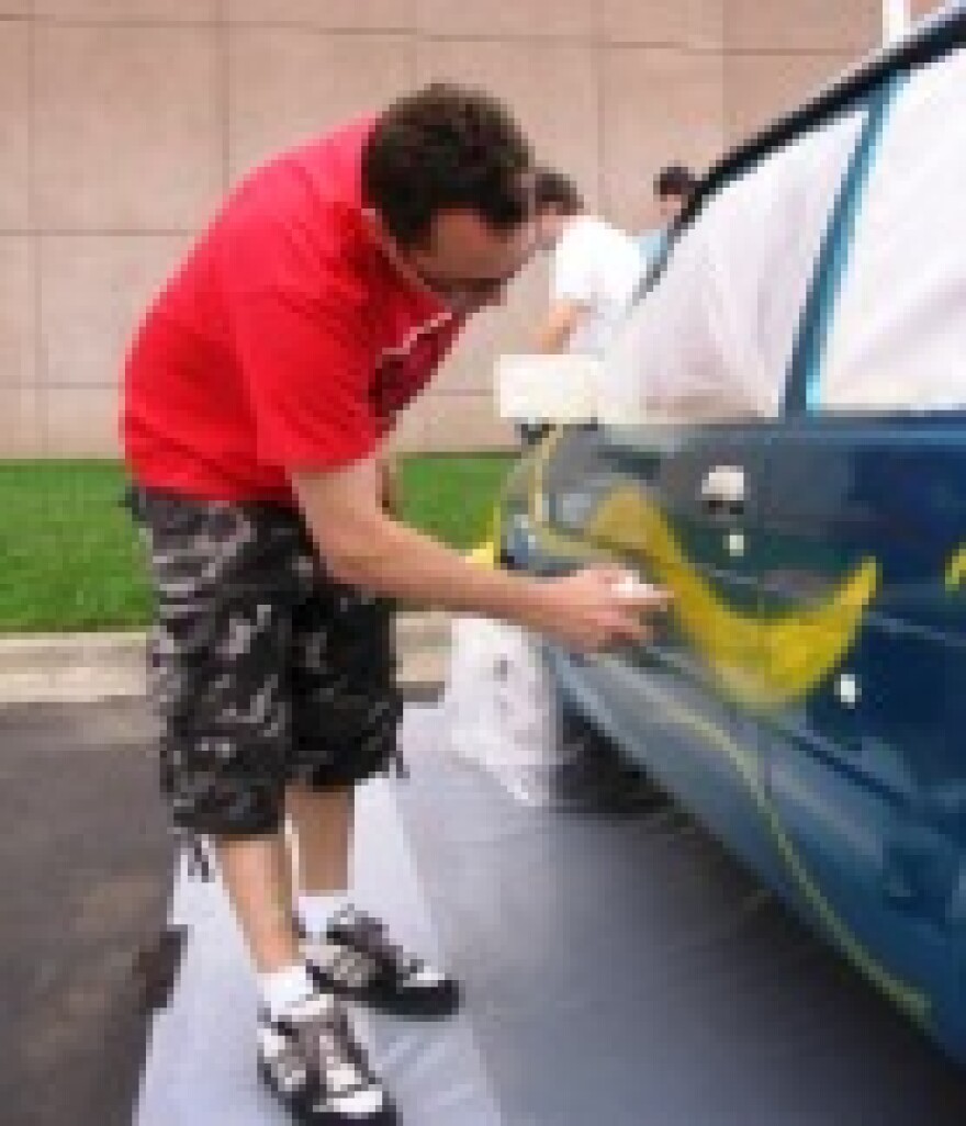 Artist-in-residence Ryan Humphrey helps students "trick out" a car in the parking lot at the Kemper Museum of Contemporary Art