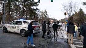 Montgomery County Police block the street as people wait outside Thomas S. Wootton High School for students in Rockville Md., Monday, Feb. 9, 2026, after a person was shot inside the school. (AP Photo/Jose Luis Magana)