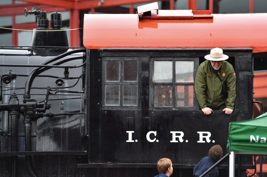 A park ranger greets students from an engine window during a tour of the Steamtown National Historic Site.