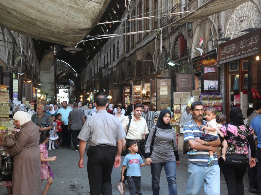 Syrians walk at the al-Bzoureya market in Old Damascus on Thursday.