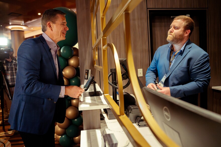 Trent Green, former quarterback for the St. Louis Rams and the Kansas City Chiefs, left, reacts after placing his first sports wager on No. 2–ranked Indiana University football winning the national championship on Monday, Dec. 1, 2025, at the Horseshoe St. Louis Casino in downtown St. Louis. The casino’s sportsbook manager Tyler Stahl, right, took the bet. Monday marked the first day Missourians could legally place sports gamble after voters enshrined the right in the state constitution last year.
