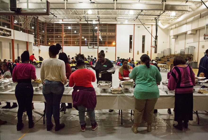 Residents line up for a Thanksgiving meal in a community gathering at Kennedy Recreation Center in Shaw.