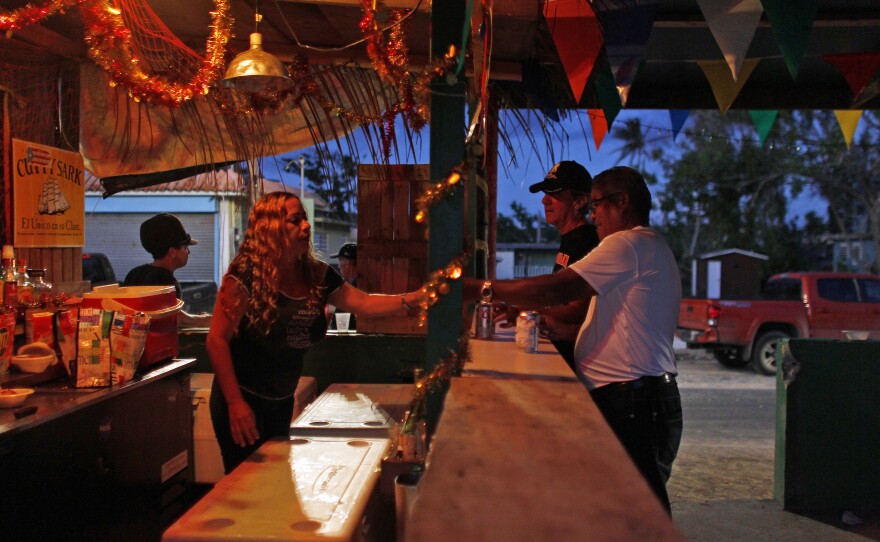 A bartender serves drinks at La Nasa bar in the Esperanza beachfront neighborhood in Vieques. The original bar was reduced to rubble by the hurricane and washed into the sea.
