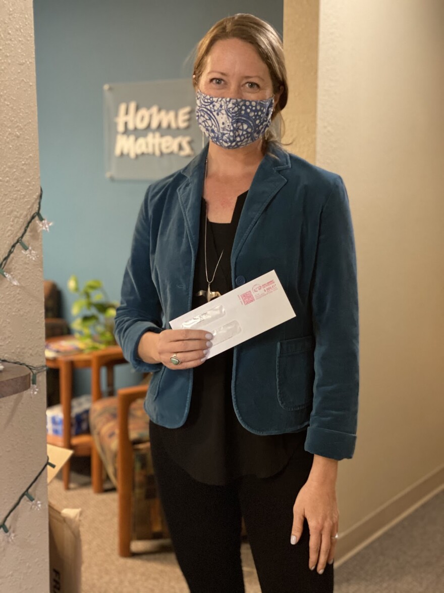 Kelly Evans, executive director of Neighbor2Neighbor, prepares to mail a rental assistance check to a landlord. During the pandemic, she says the need for help has been “overwhelming.”