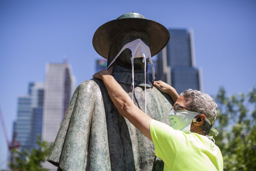 Jeff Levine puts a face mask over the statute of Stevie Ray Vaughn at Auditorium Shores on April 16.