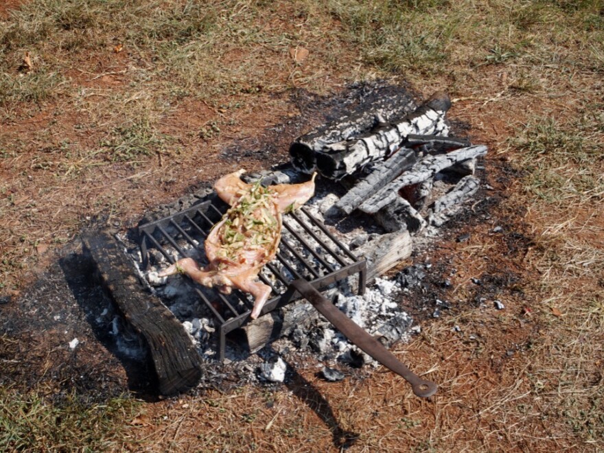 Twitty grills the peppered rabbit over an open fire.