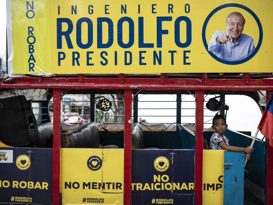 A child sits in the "Rodolfoneta" holding a national flag during a caravan showing support for presidential candidate Rodolfo Hernandez a day ahead of the country's presidential run-off, in Bucaramanga, Colombia, Saturday, June 18, 2022.