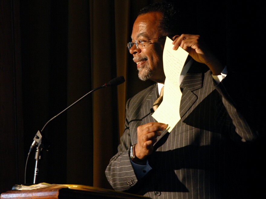 Henry Louis Gates Jr. uses a folded piece of paper to show how information on African American writer Harriet E. Wilson was lost when copied to microfilm, while giving a speech about the author in 2004 at the Milford Town Hall in New Hampshire.