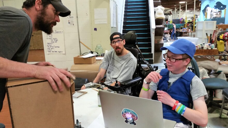 Instructors Spencer Allen (left) and Connor Fogal (middle) work with camp participant Logan Mason (right).