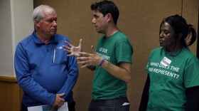 Eric Rosengren, left, the president of the Federal Reserve Bank of Boston, talks with Ady Barkan, campaign director for Fed Up, before the opening night reception at the annual invitation-only conference of central bankers from around the world. (Brennan Linsley/AP)