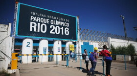 Workers stand at an entrance to the Olympic Park construction site on June 8, 2015 in the Barra da Tijuca neighborhood of Rio de Janeiro, Brazil.  (Mario Tama/Getty Images)