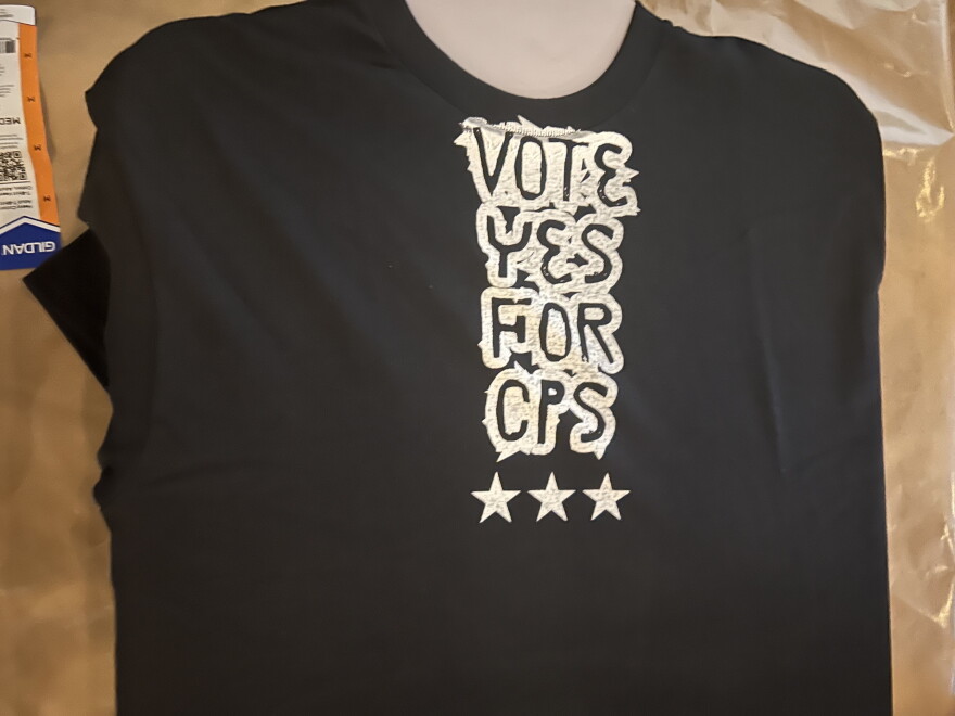 A freshly printed T-shirt reads "Vote Yes for C-P-S."