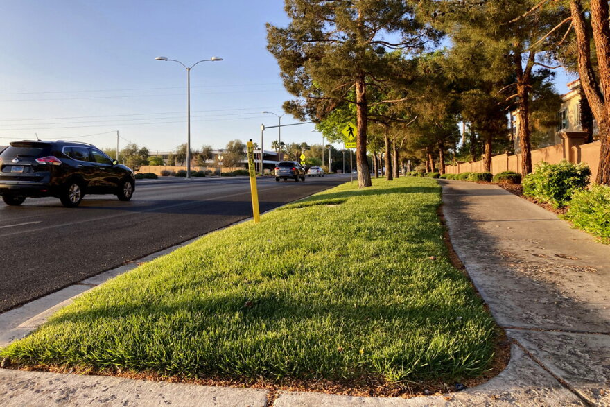 FILE - Traffic passes a grassy landscape on Green Valley Parkway in suburban Henderson, Nev., on April 9, 2021. In November 2022, some of the largest water agencies in the western United States agreed to a framework that would dramatically reduce the amount of decorative grass in cities such as Los Angeles, Las Vegas, Salt Lake City and Denver. The agreement comes as the seven states that rely on the overtapped Colorado River are facing a dire future with less water to go around. (AP Photo/Ken Ritter, File)