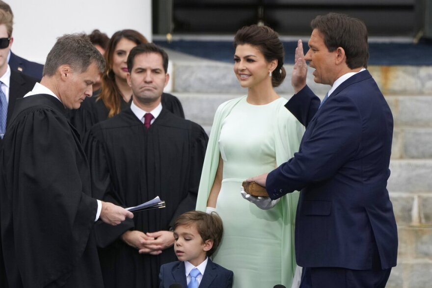 Florida Gov. Ron DeSantis, right, is sworn by Florida Supreme Court Chief Justice Carlos Muniz, left, to begin his second term during an inauguration ceremony outside the Old Capitol Tuesday, Jan. 3, 2023, in Tallahassee, Fla. Looking on is DeSantis' wife, Casey, second from right, and their son, Mason.