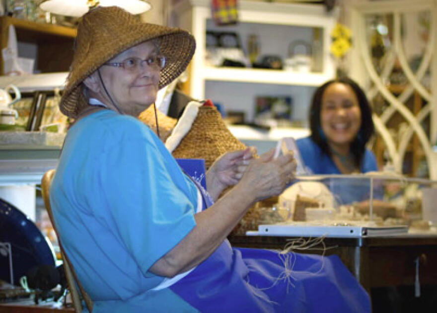 Artist Lois Thadei in woven hat, photographed at Ginger Street in Olympia during Art Walk. 