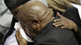 A mourner is comforted during a memorial in Charleston, S.C., Friday, June 17, 2016 on the anniversary of the killing of nine black parishioners during bible study at Mother Emanuel AME Church.