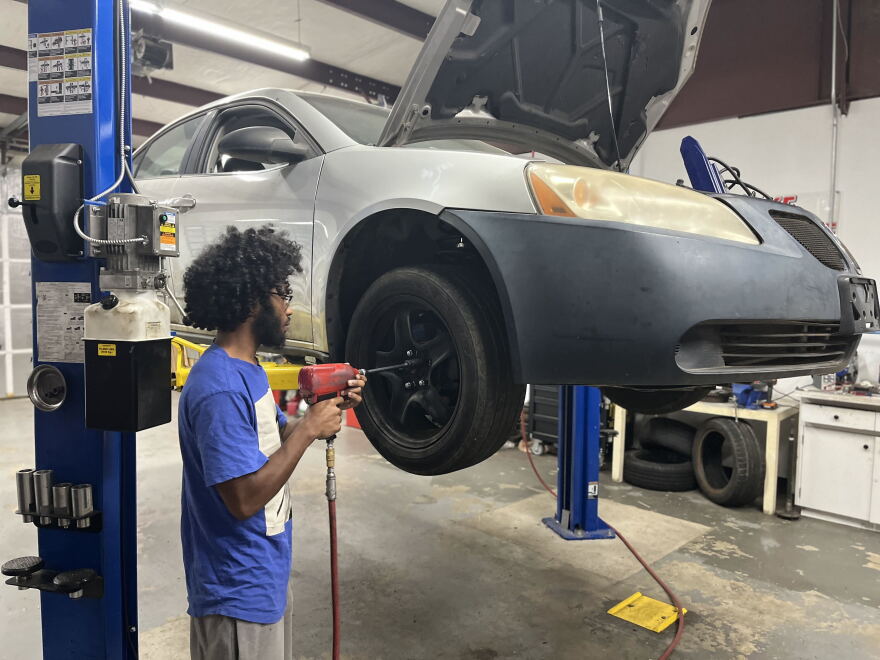 Tomas Murdock, 21, changes a tire nearby as part of the NCIA program.