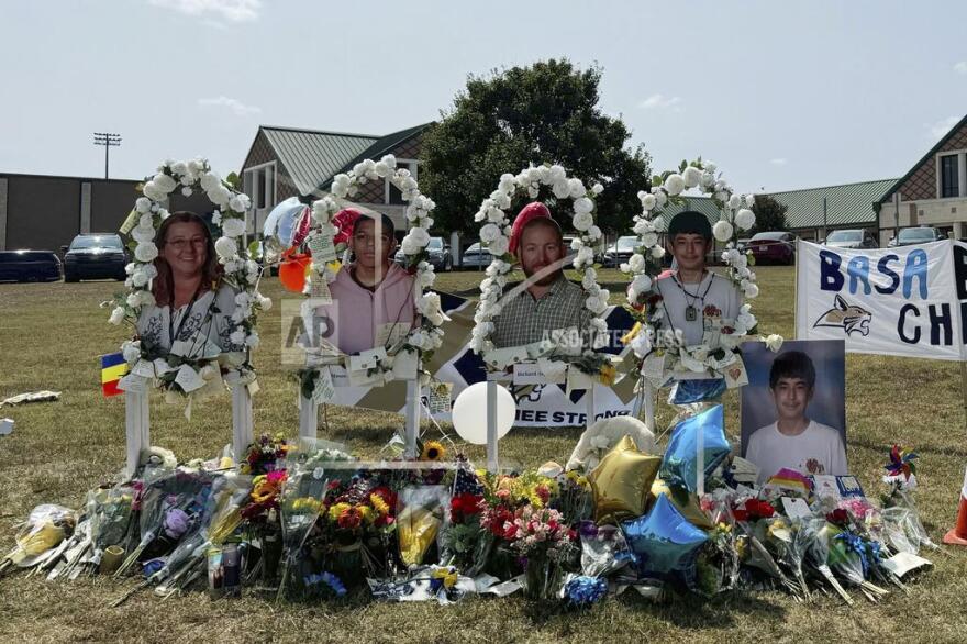 FILE - A poster with images of shooting victims from left, Cristina Irimie, Mason Schermerhorn, Richard Aspinwall and Christian Angulo is displayed at a memorial outside Apalachee High School, Sept. 10, 2024, in Winder, Ga. (AP Photo/Charlotte Kramon, File)