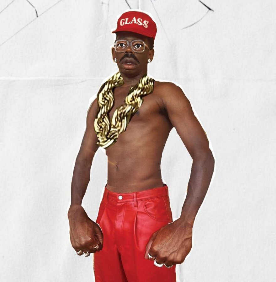 a still of a man wearing red pants and a big gold chain 