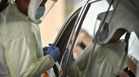 Tyrone Tyner, a medical assistant at Truman Medical Center prepares a drive through patient for a COVID-19 test on Oct. 28.