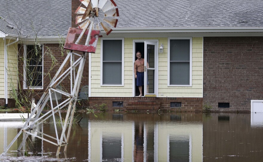 On Sunday, a man peers from his flooded home in Lumberton, N.C.