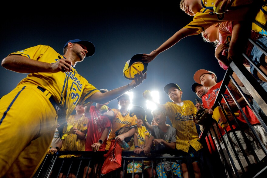 Retired St. Louis Cardinals pitcher Adam Wainwright signs autographs after making a surprise appearance on the mound during a banana ball game between the Savannah Bananas and the Party Animals on Friday, July 18, 2025, at Busch Stadium in downtown St. Louis.