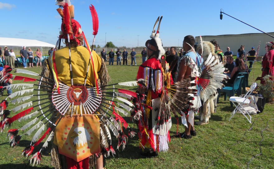 People at powwow, standing in a circle. 
