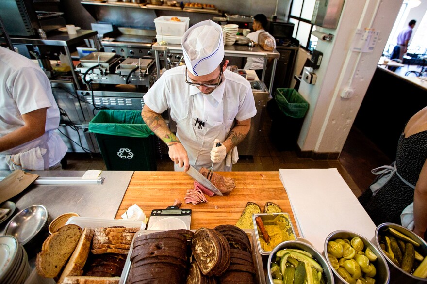 Tyler Sundet, a co-owner of Mamaleh's, carves up some corned beef.