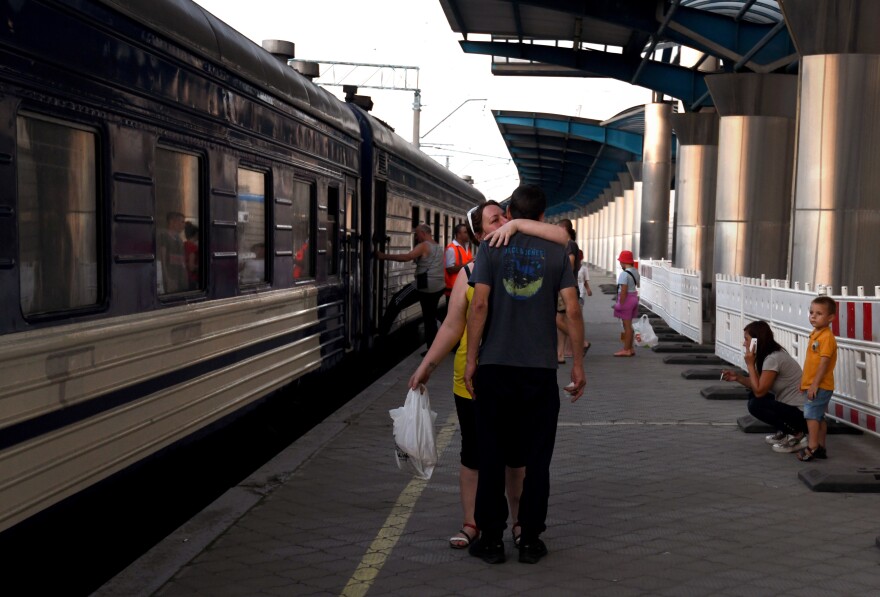 Ukrainians are on a platform at a station in Dnipro, Ukraine, as an evacuation train arrives carrying people from the Donbas, on July 8.