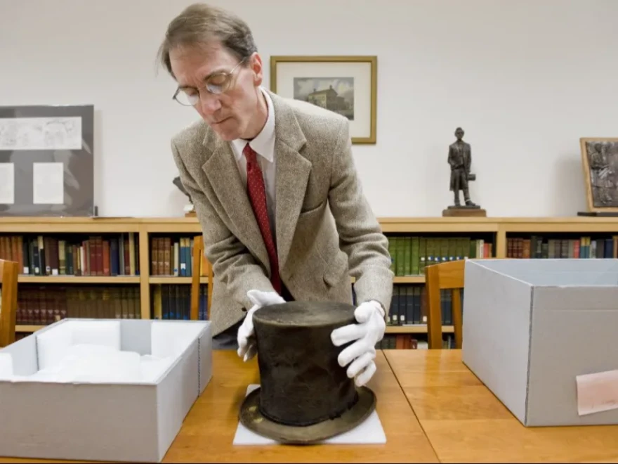 James M. Cornelius, former curator of the Lincoln Collection at the Abraham Lincoln Presidential Library and Museum in Springfield shows the Abraham Lincoln hat in the museum’s collection in 2012.