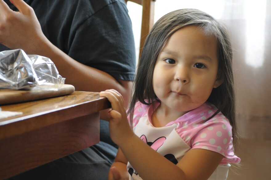 Alesha Tangman's daughter Lucy steals bites of Maktak from her mother's plate. She loves eating the dish with Kunniak's Salt and Spice mixture. (Erin McKinstry, Alaska Public Media)