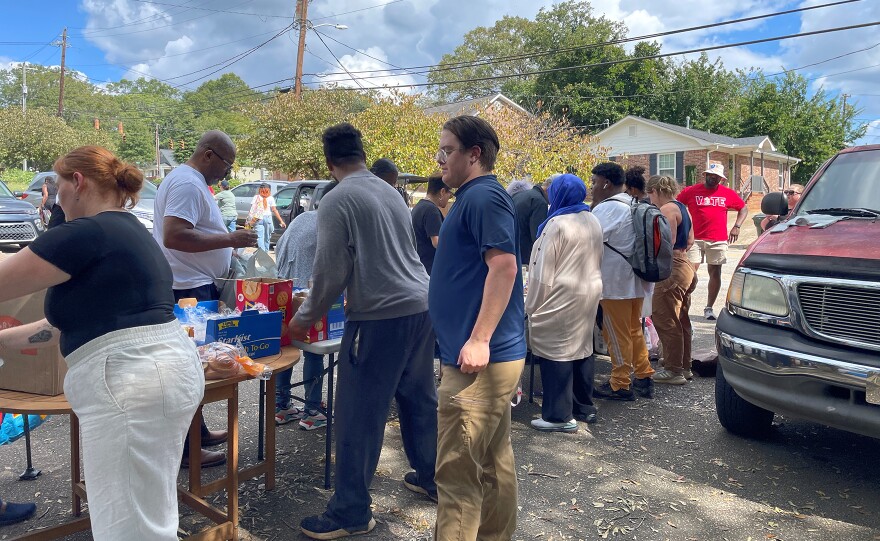 Residents of Greenville's Nicholtown neighborhood line up for some weekend food at Nicholtown Community Center. Despite that power is coming back on in the city, residents who live near substations damaged by Tropical Storm Helene are bracing for a second week without power.