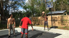 Tyree Thomas, 16, shoots a free throw on the new 24x30 foot basketball court in his backyard the Gainesville Police Department and the Basketball Cop Foundation gave him after noise complaints of Thomas and his friends being loud in the street. (Ryan Summers/WUFT News)