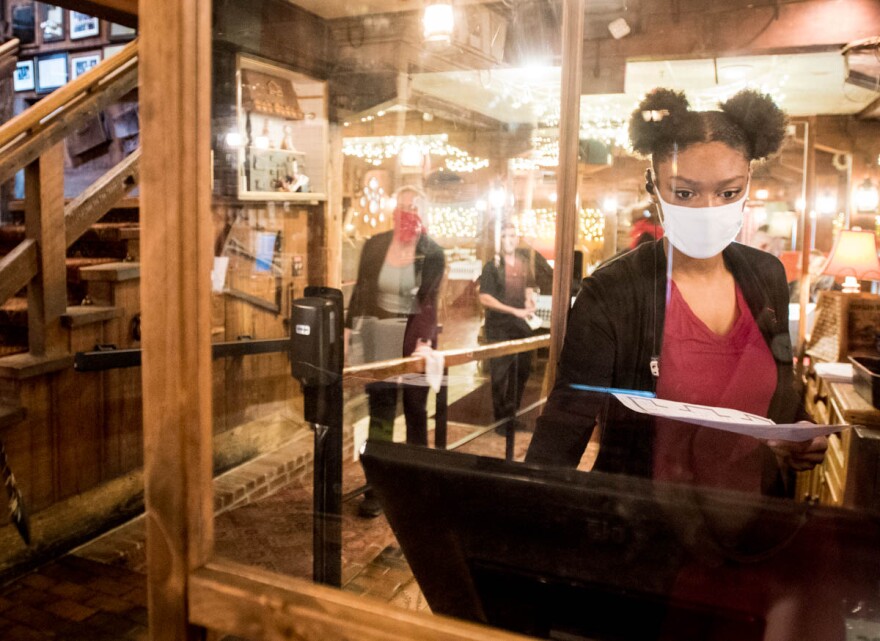 Kennedy Campbell, a host at Angus Barn in Raleigh, NC, prepares for dinner guests to arrive on Saturday behind a newly installed sneeze guard. As the state of North Carolina transitions from the Stay At Home order to Phase 2 of easing COVID-19 restriction