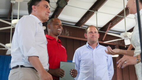 Lexington businessman Nate Morris, former Kentucky Attorney General Daniel Cameron and U.S. Congressman Andy Barr flip a coin to decide their speaking order at the annual St. Jerome Picnic in Fancy Farm in August 2025. The three are the top Republican contenders vying for Sen. Mitch McConnell’s seat.