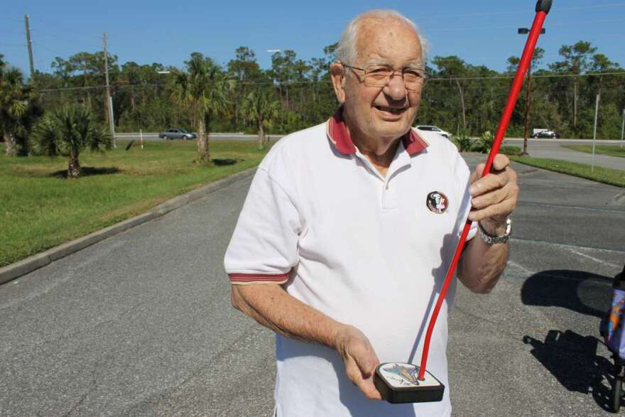 Charlie Madge with one of his own putters. Photo: Matthew Peddie, WMFE