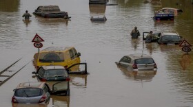 Helpers check for victims in flooded cars on a road in Erftstadt, Germany, on July 17, 2021. Due to strong rain falls, the small Erft river went over the banks causing massive damages. (Michael Probst/AP)