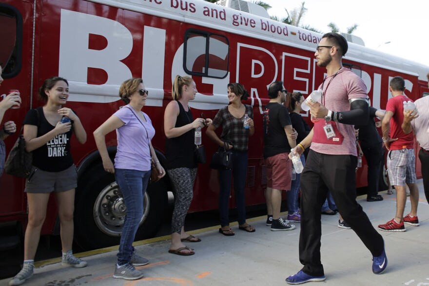 Arturo Roque passes out water to those waiting in line to donate blood in the aftermath of the Orlando mass shooting in Miami Beach, Fla. (Lynne Sladky/AP)