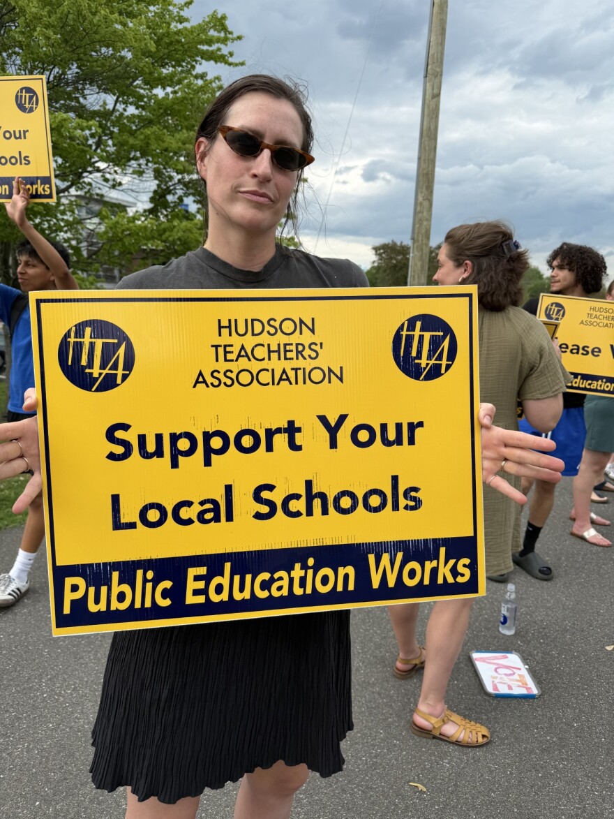 Hannah Black, a parent in the Hudson City School District, holds a sign at a rally held by Hudson teachers.