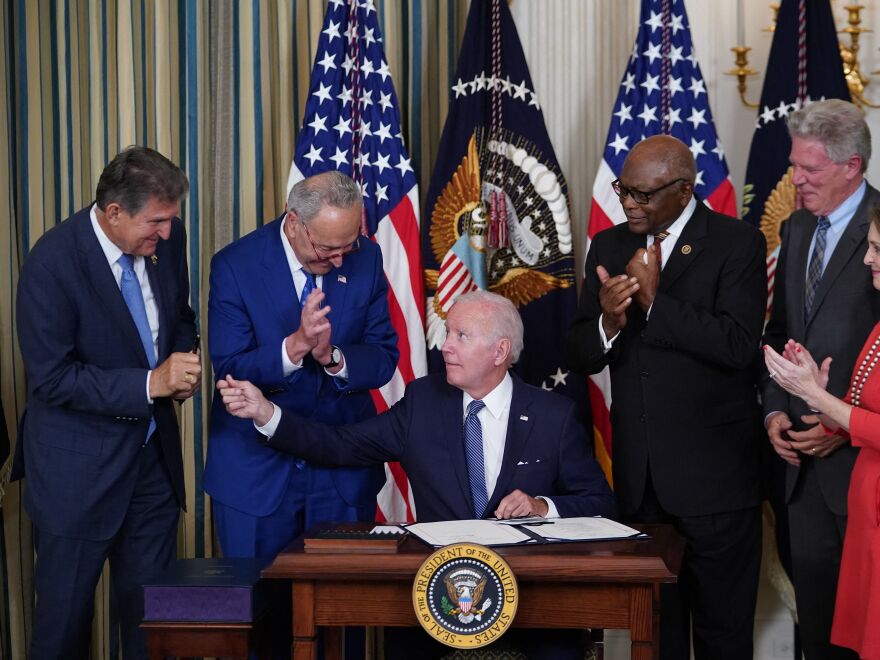 President Biden hands a pen to Sen. Joe Manchin during the signing ceremony for the Inflation Reduction Act. Manchin was a key hold-out during negotiations, insisting on a smaller spending bill.